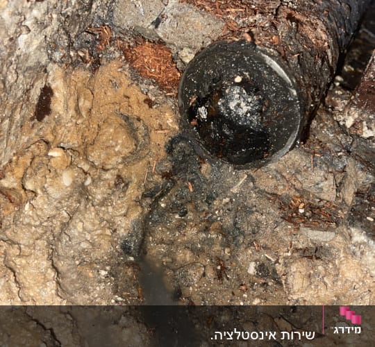 צינור שבור עם נזילת מים באדמה